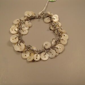 White fluffy dog sitting on wooden deck outdoors