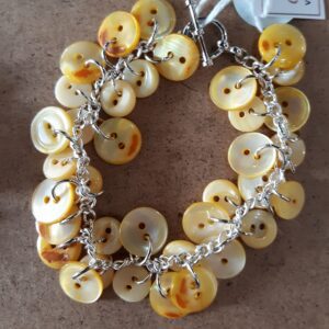 Woman in yellow sweater smiling outdoors in autumn